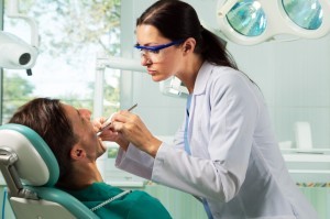 Woman dentist examining male patient