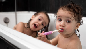 Little girl brushes teeth in bathtub
