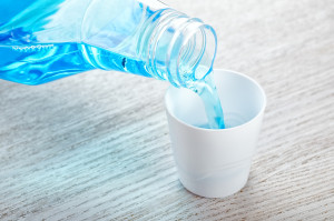 Mouthwash from plastic bottle flowing into cap